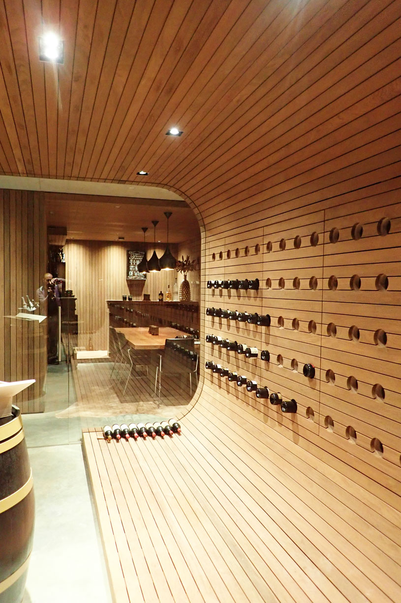 design wijnkelder op maat gemaakt in massief hout met ronde vormen